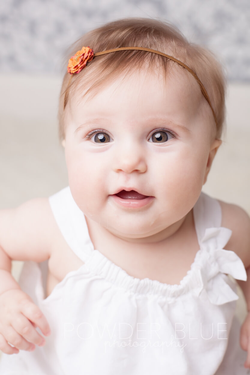 7 moth old girl baby smiling wearing a headband