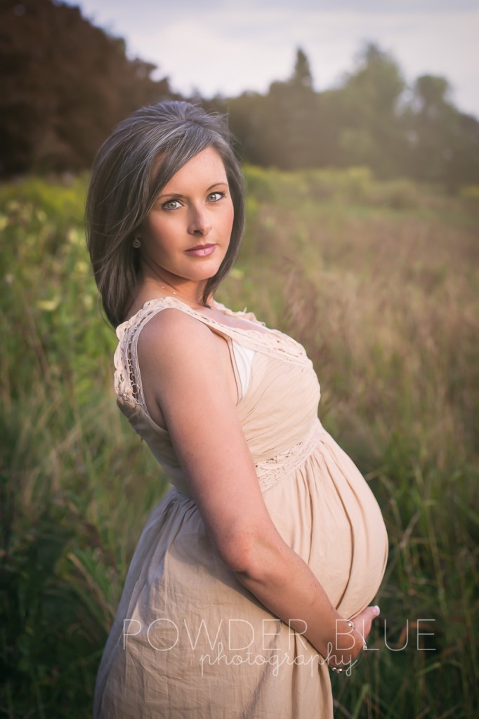 Maternity portrait beautiful eyes in a field of tall grasses and hazy golden hour lighting. © 2013 Powder Blue Photography. www.powderbluephoto.com