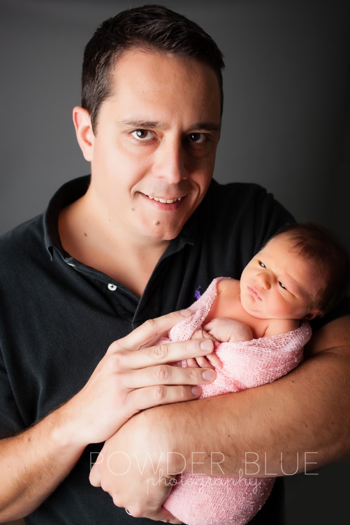 dad holidng newborn baby girl with eyes open © 2013 Powder Blue Photography. www.powderbluephoto.com