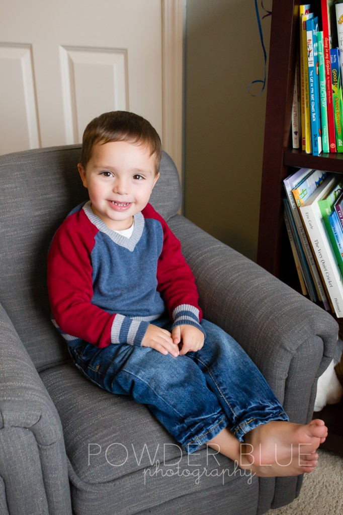 two year old toddler sitting on grey tweed chair