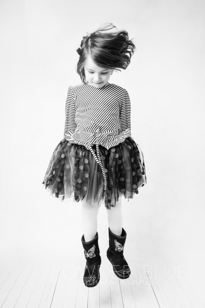 girl jumping black and white studio portrait