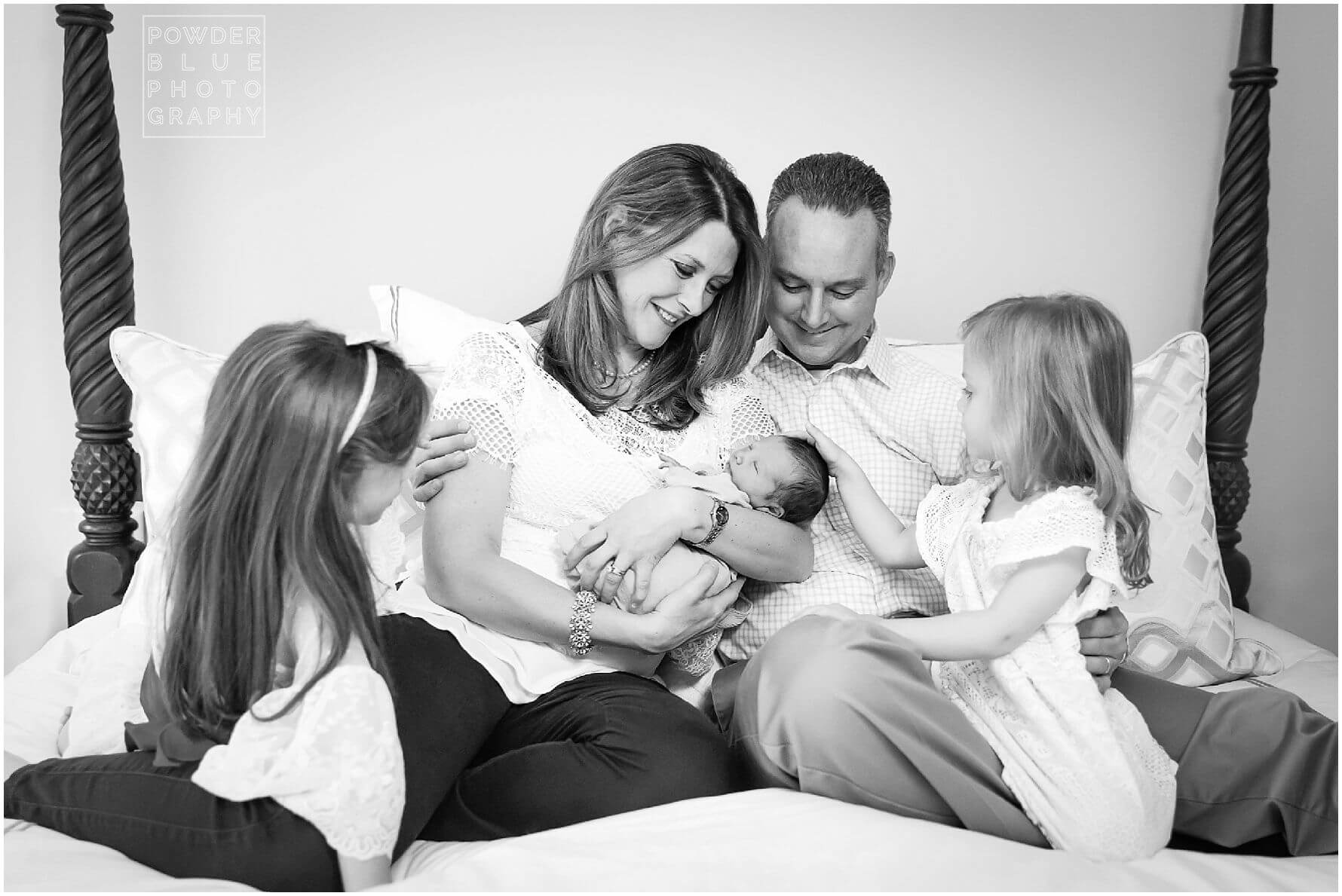 black and white image of family of five with newborn baby boy on a bed in upper st clair.