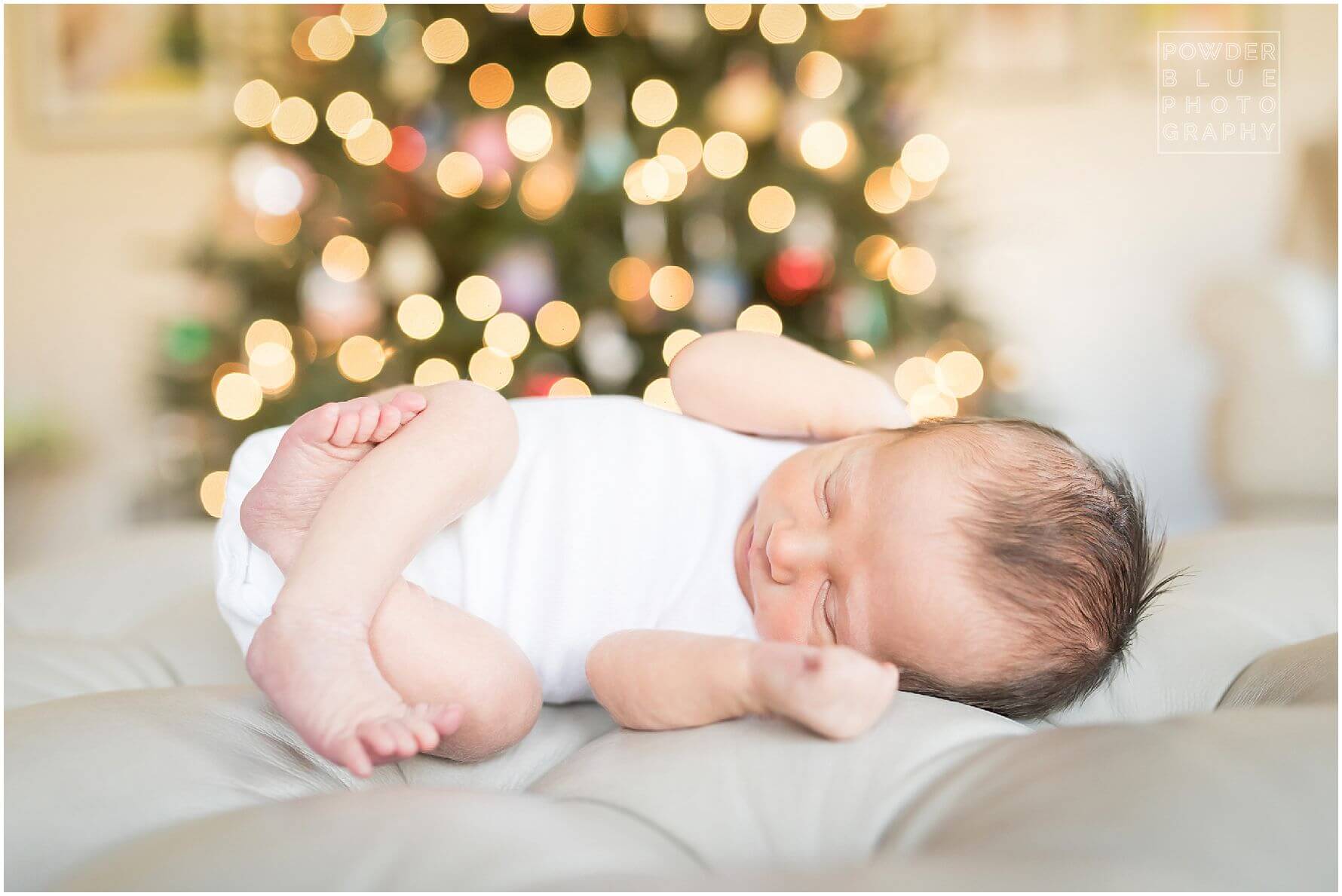 pittsburgh newborn photographer missy timko photographed this baby iboy in front of the christmas tree with twinkling lights behind him. wide open aperture with christmas tree as backdrop.