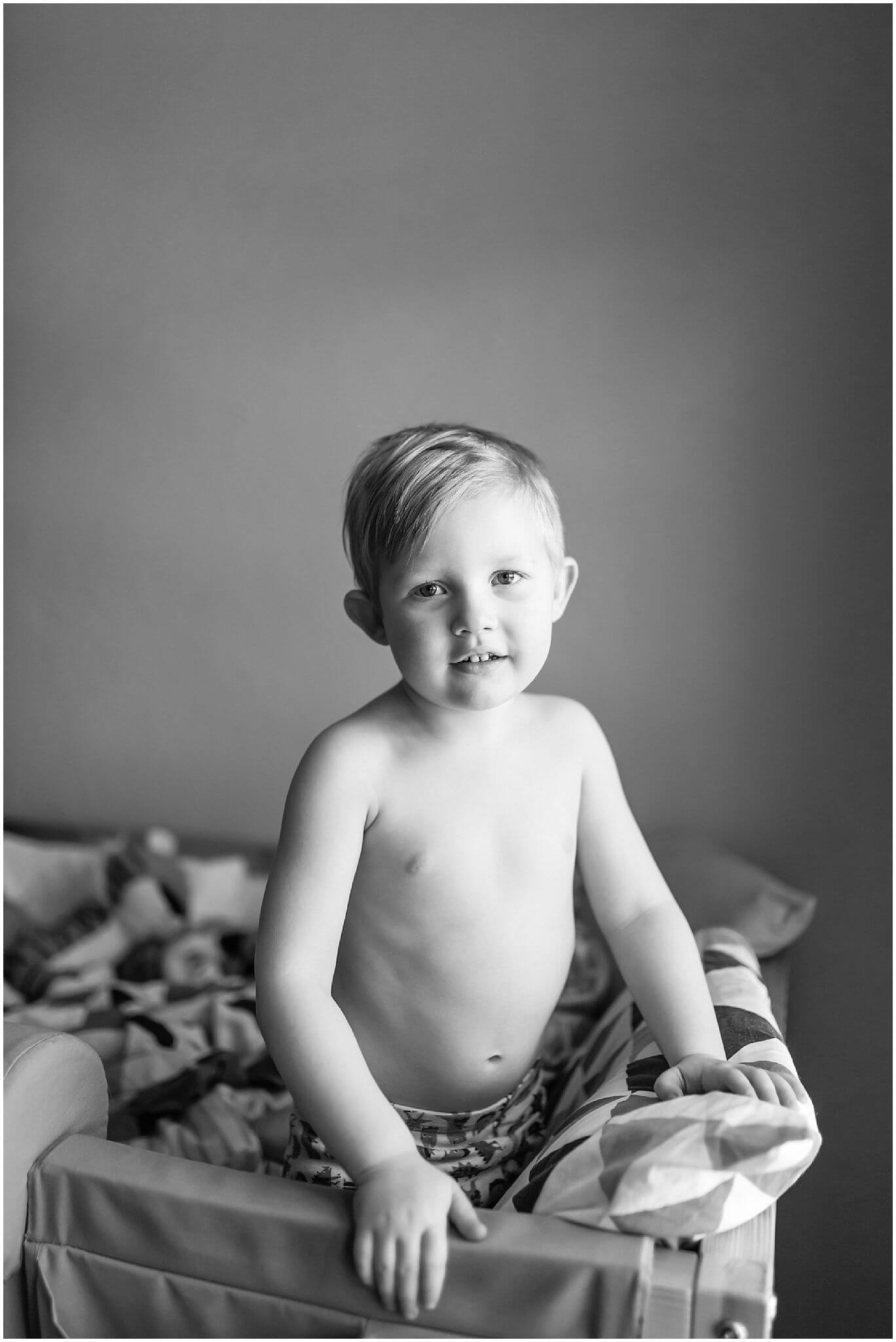 child on a bed looking pensive black and white