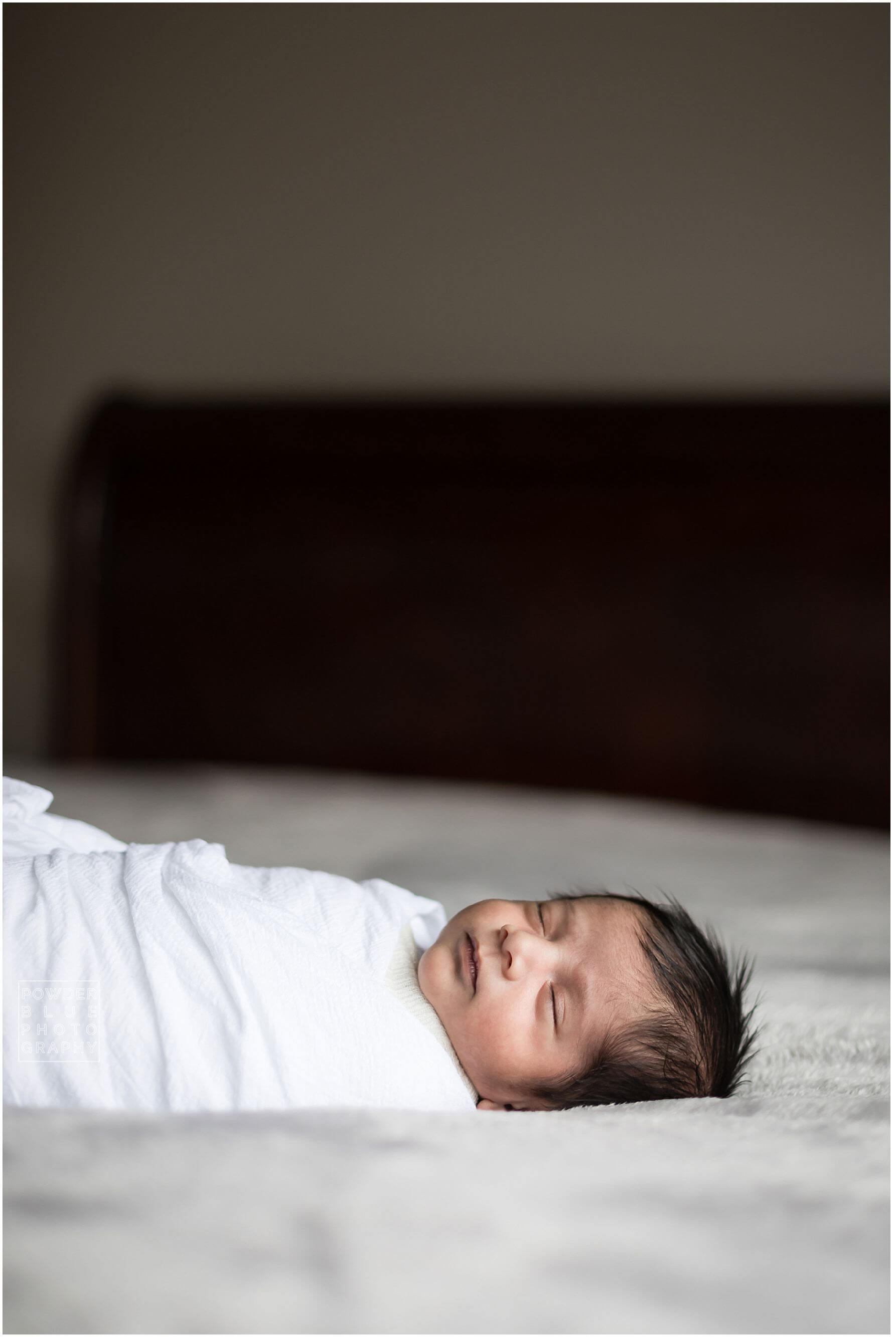 pittsburgh newborn photographer lifestyle photography session. newborn baby in black & white and color portraits on a bed in a home.