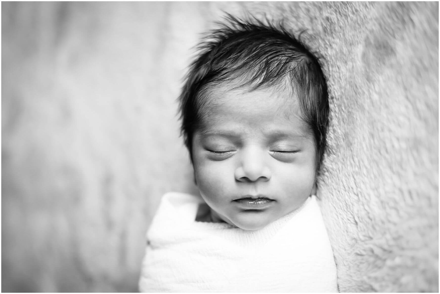 pittsburgh newborn photographer lifestyle photography session. newborn baby in black & white and color portraits on a bed in a home.