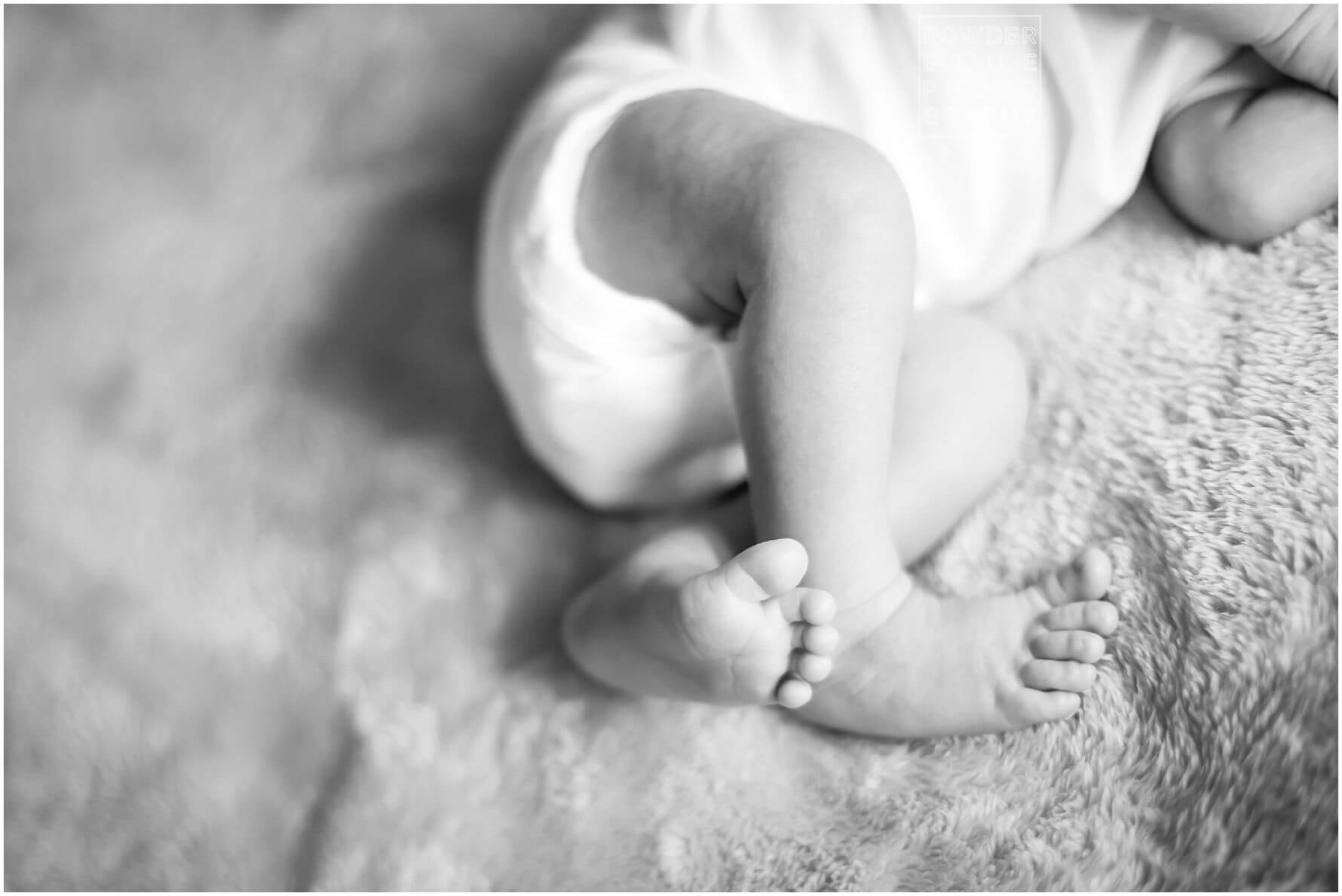 pittsburgh newborn photographer lifestyle photography session. newborn baby in black & white and color portraits on a bed in a home.