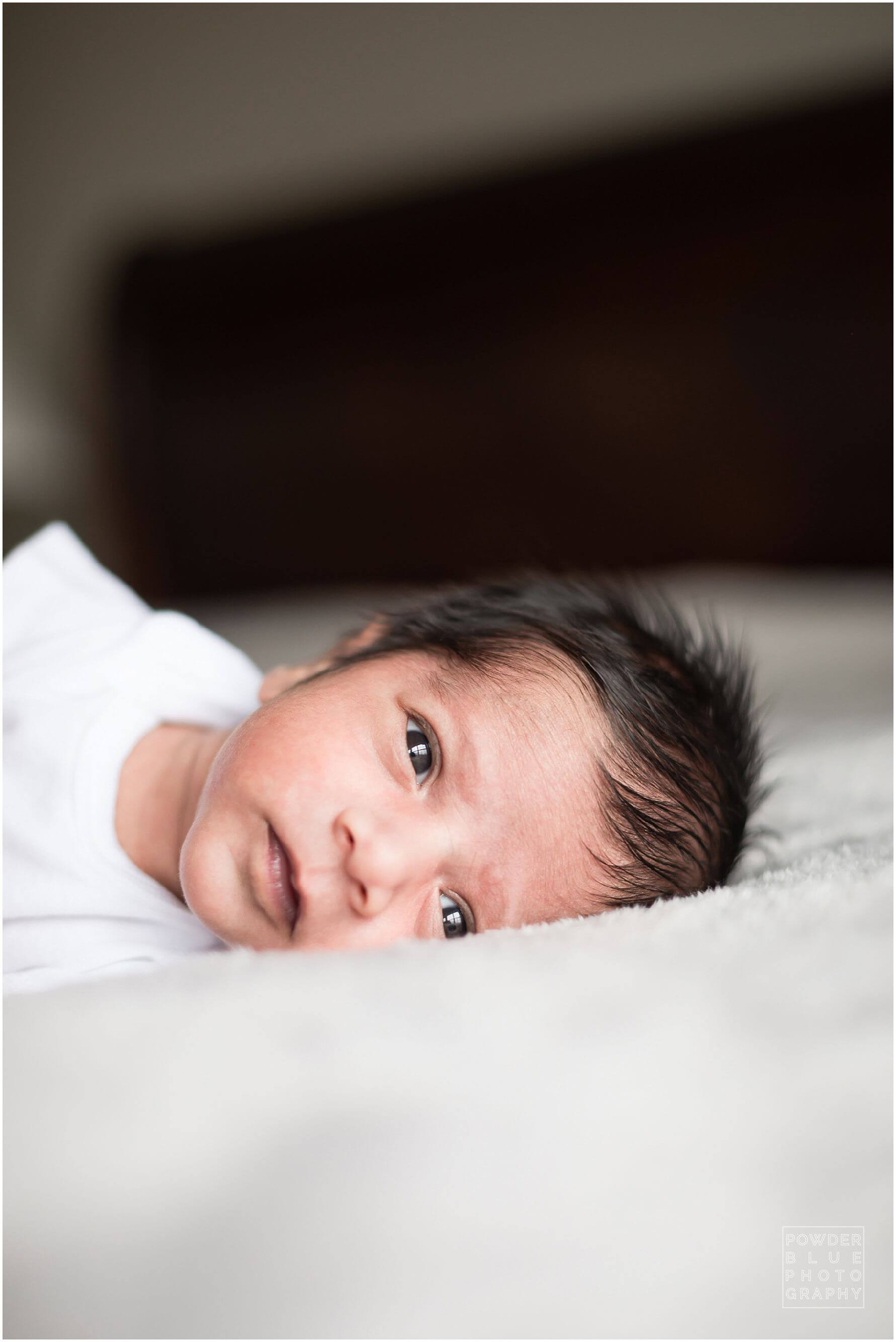 pittsburgh newborn photographer lifestyle photography session. newborn baby in black & white and color portraits on a bed in a home.
